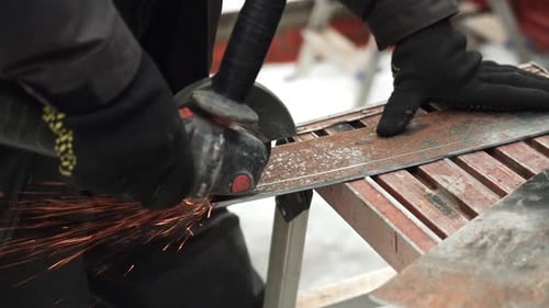 Arbeiter, der Metallrohre mit einem Winkelschleifer schneidet. Helle Funken und
Blitze