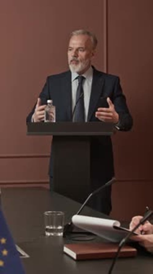 Man in Suit Giving Corporate Speech at Podium