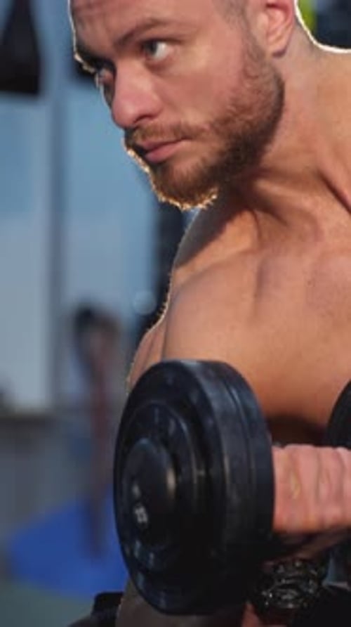 Man Lifting Dumbbell in the Gym for Workout