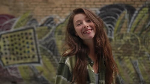 Smiling Young Woman Posing in front of Graffiti