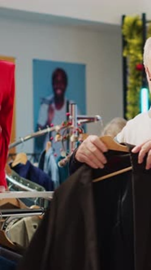 Vertical Video Man Looking at Shirt in Clothing Store