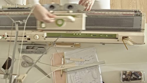 Top view of woman works behind a knitting machine 4K
