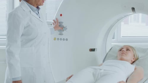 In Medical Laboratory Radiologist Controls MRI or CT or PET Scan with Female Patient Undergoing Pro
