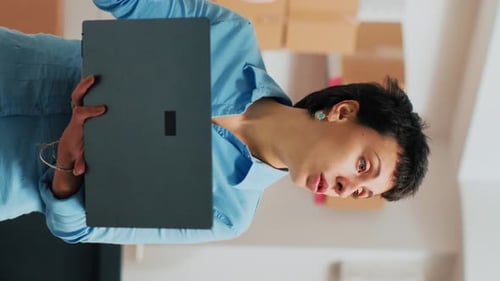 Adult Woman Speaking With Laptop in Warehouse