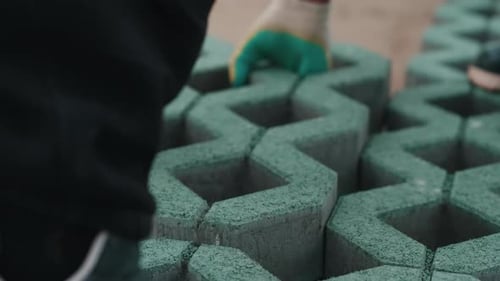 Close-up of a Worker Installing Green Concrete Eco-Pavers