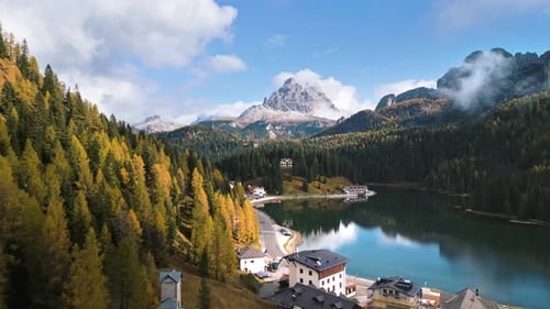Vue aérienne par drone du lac Misurina entouré d'une forêt d'automne avec les Trois Pics de Lavaredo