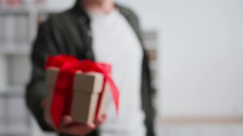 Offering a Birthday Gift With a Red Ribbon