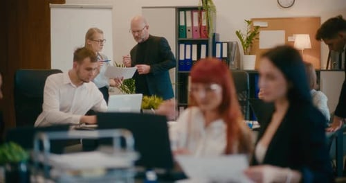 Kollegen diskutieren über Dokumente im Büro