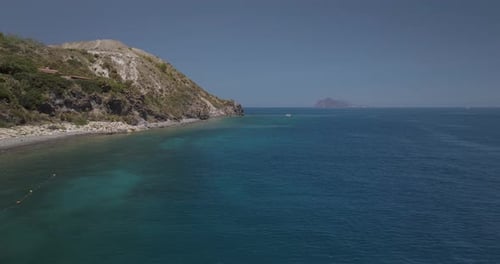 Aerial view of tranquil coastline with boats and rocky cliffs, Italy.