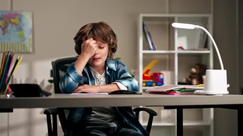 Boy at Desk with Hand on Head