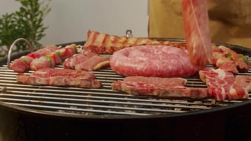 Traditional Spanish Barbeque Big Sausage Chorizo Botifarra Pork and Beef Ribs on Grill with Fire
