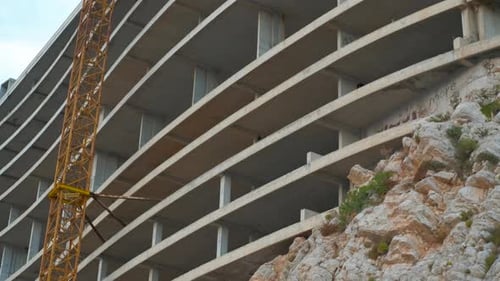 Sitio de construcción de edificio de concreto sin terminar con grúa