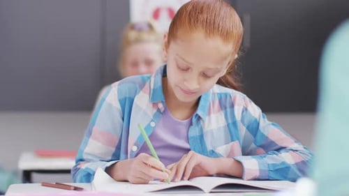 Elementary School Student Writing at Her Desk