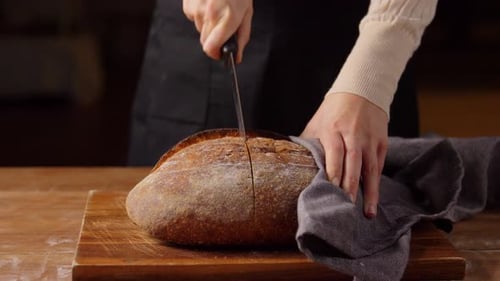 Bäcker schneidet Brotlaib in Zeitlupe