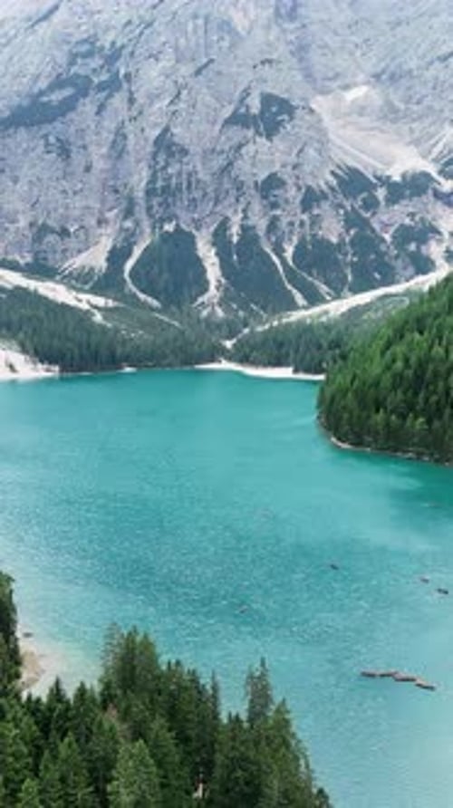Drohnenaufnahme des türkisfarbenen Wassers des Pragser Wildsees, umgeben von dichtem Alpenwald und