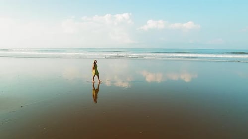 Stunning reflection of woman walking on dark sand beach during Costa Rica visit