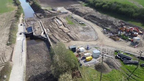 Vuelo aéreo sobre un sitio de nuevas construcciones en el desarrollo de una esclusa de canal en el norte de Inglaterra