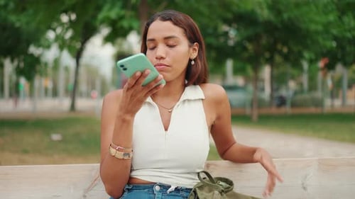 Smiling Woman Using Voice Assistant on Smartphone
