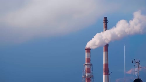 Two Chimneys of Heat and Power Station Emit White Smoke at Blue Sky