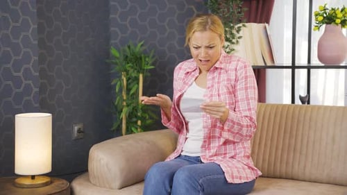 Woman Reacts Negatively to News Indoors