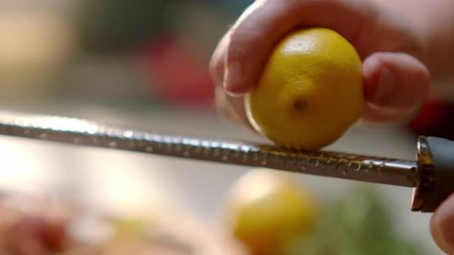 A person is grating a lemon