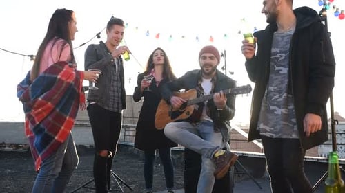 Friends Enjoying a Rooftop Party with Music