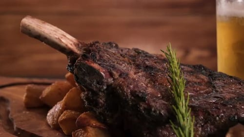 Carving board stacked with enormous tomahawk beef steak over roasted potatoes and wild mushrooms, cl