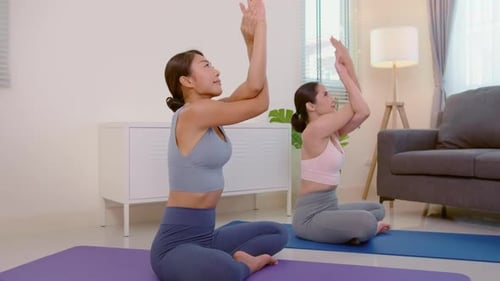 Women Practicing Yoga in Bright Home Studio