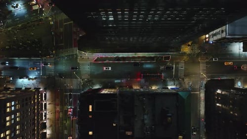 Aerial View of Cars Driving Along the Brightly Lit Streets of New York City at Night with