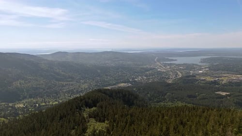 Vista aérea panorámica en la cima de la montaña con vistas al bosque siempre verde y la ciudad al fondo en Was