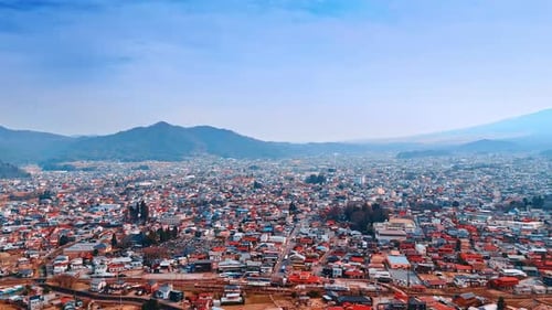 Low-rise densely built cityscape of Tokyo on sunny day. Hazy view of Mount Fuji, Honshu, Japan.