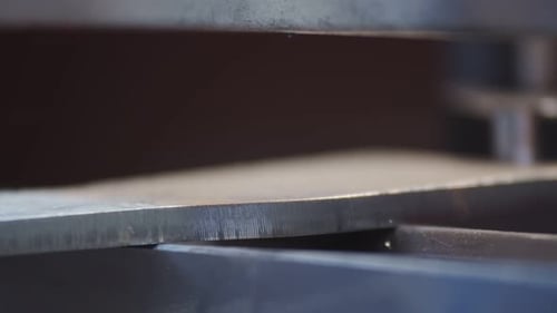 Metal being run through rollers in factory