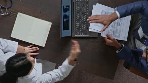 Head of Medical Clinic Shaking Hands with Female Doctor for Successful Operation