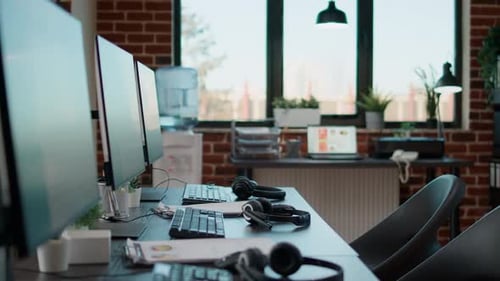 Nobody in empty call center workstation with computers and audio instruments. No people at customer
