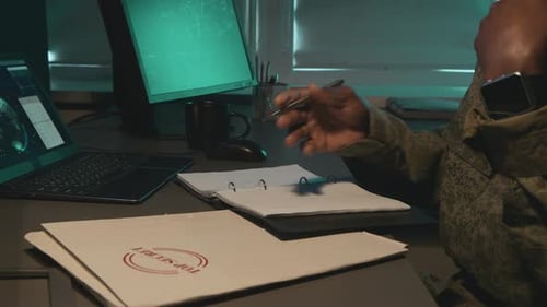 Man Writing Top Secret Notes at Desk