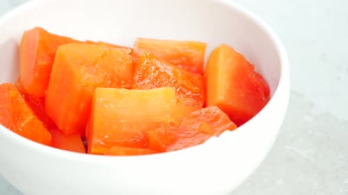 Ein Stück Papaya auf weißem Teller
