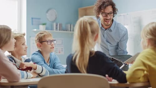 Elementary School Physics Teacher Uses Interactive Digital Tablet to Show to a Classroom of Smart C
