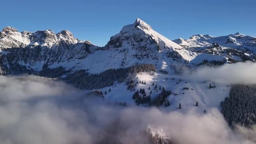 Majestic Snow Capped Alpine Peaks Emerging Above a Soft Cloud Sea