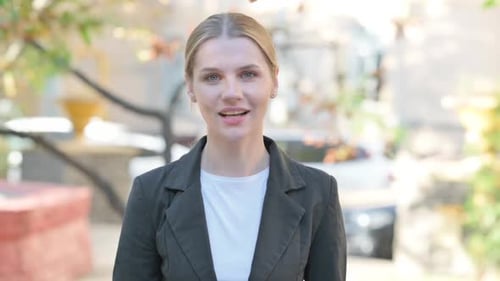 Young Woman Talking and Waving in City Location