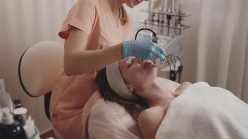 Esteticista profesional que realiza un tratamiento facial de iontoforesis