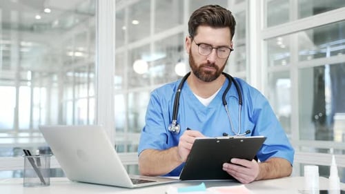 Doctor Takes Notes at Desk in Bright Office