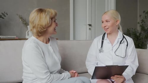 Female Doctor Consults with Patient at Home
