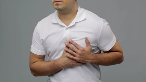 Man in pain clutching his chest and stomach
