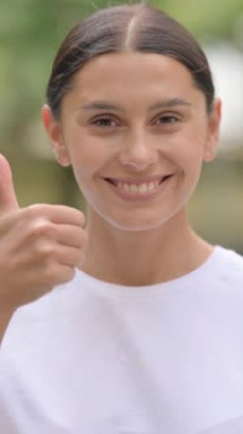 Smiling Woman Gives a Thumbs Up of Approval