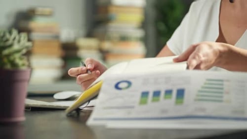 Closeup of Female Hands Writing with a Pen in a Notebook in the Office