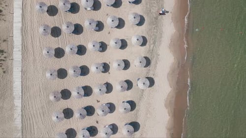 Aerial View of an Amazing Empty Sand Beach with Straw Beach Umbrellas and Turquoise Clear Water
