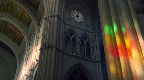 sunlight falls trough stained glass inside la almudena cathedral in madrid. fast camera movement