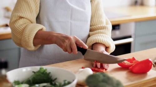 Woman Cuts Red Pepper on Cutting Board