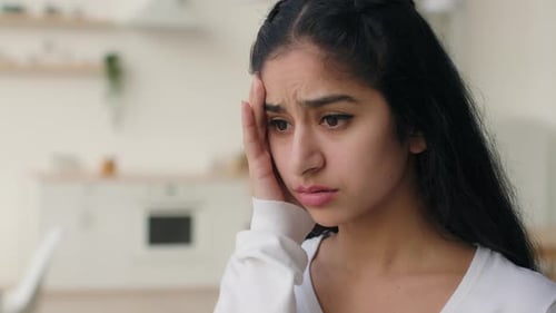 Young Woman Experiencing a Headache Indoors