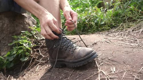 Man Tying Hiking Boot Laces in Nature